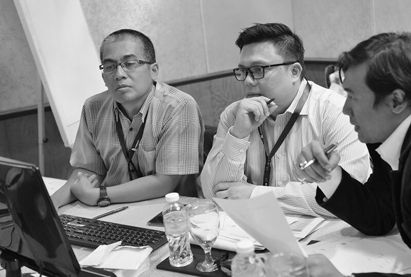 Client story Pertamina - meeting 3 men around computer